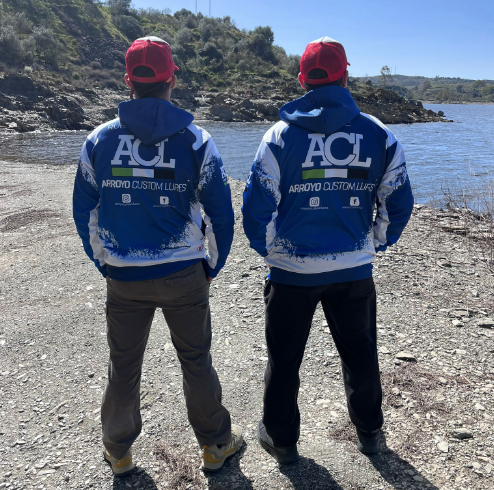 Camiseta Q53 con llampuga dorado sobre un fondo colorido y verde.