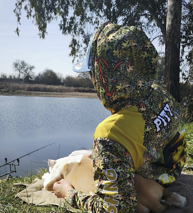 Pescador sentado junto a un lago, con una caña de pescar 